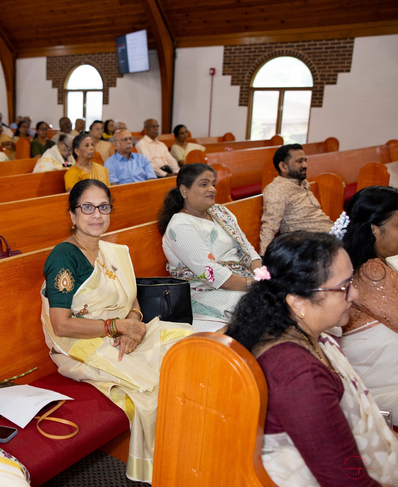 Women in traditional sarees in church pews