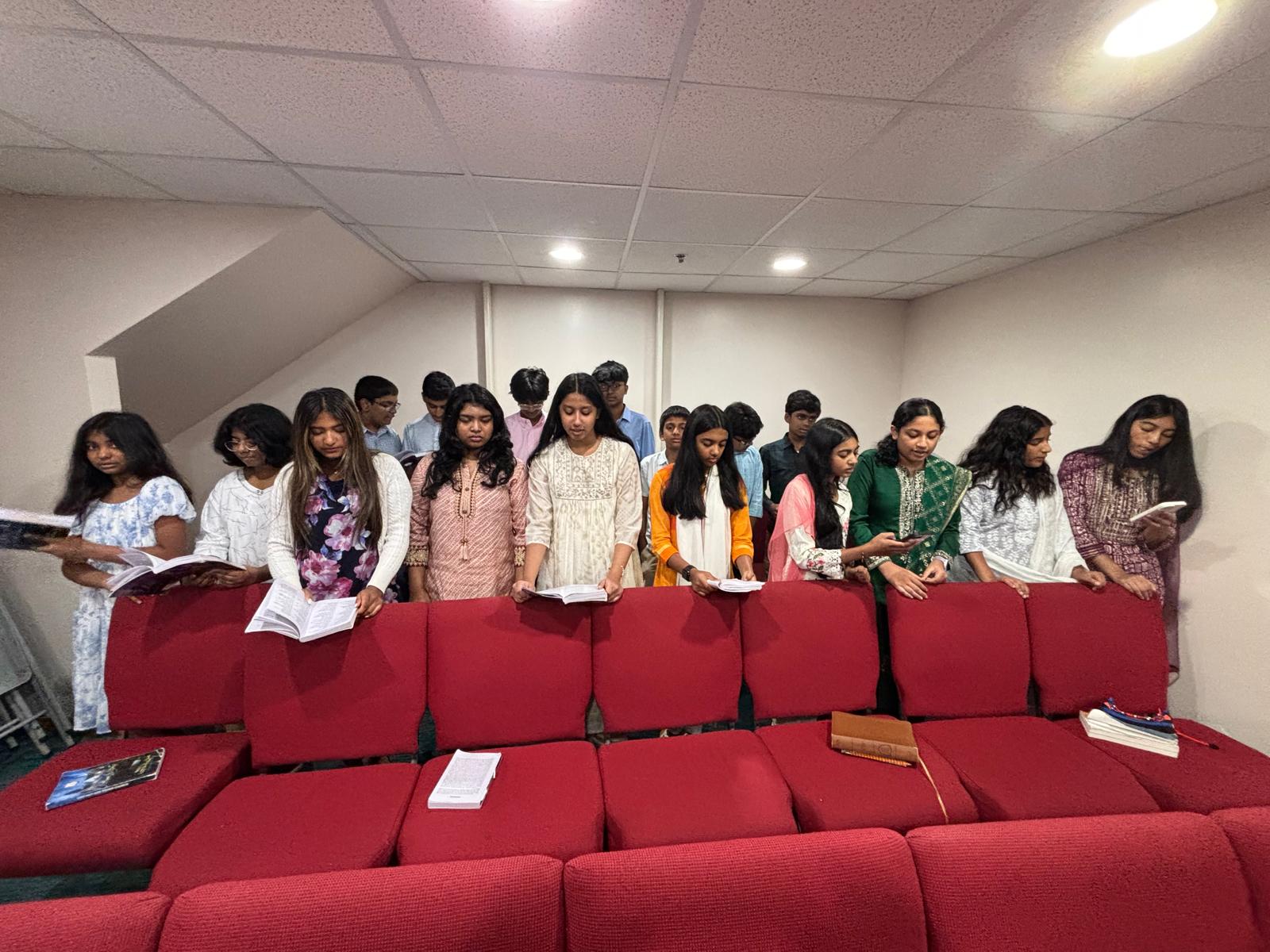Youth in prayer with hymnals